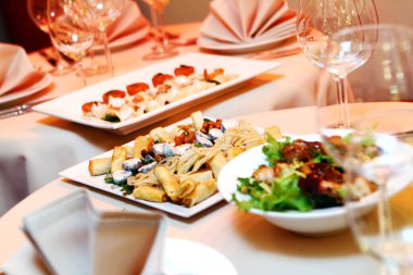 Restoran servisi ve atıştırmalıklarla dolu bir ziyafet masası.