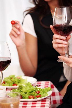 Sağlıklı salata ve kırmızı şarap bir restoranda kare masa örtüsü üzerinde.