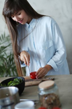 Yemek pişirmek. Kız mutfakta yemek pişiriyor.