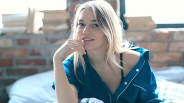 Genç ve güzel bir kadın evde dinleniyor. 