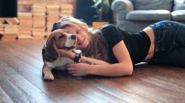 Evde köpekle oynayan güzel genç bir kadın.