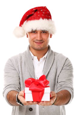 Beyaz arka planda gülümseyen Noel Baba şapkalı genç ve yakışıklı bir adam.