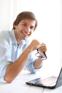 Ofiste poz veren mavi gömlekli yakışıklı bir genç.