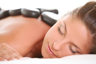 Sırtında spa taşları olan güzel beyaz kadın portresi.