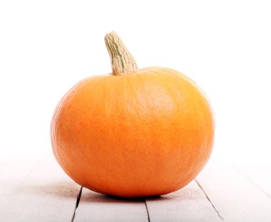 Ahşap bir masanın üzerindeki turuncu balkabağı.