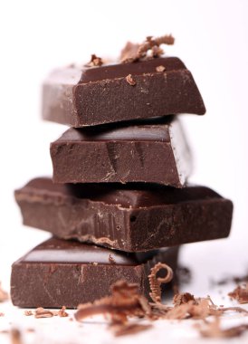 Beyaz arka plana karşı siyah çikolata parçaları