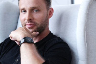 Sandalyede oturan yakışıklı adam.