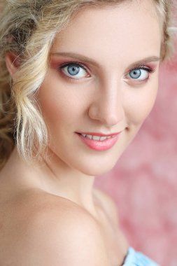 Mavi gözleri ve kıvırcık saç modeli ile güzel kız