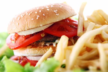 Salata yapraklarında ateş olan büyük ve lezzetli bir hamburger.