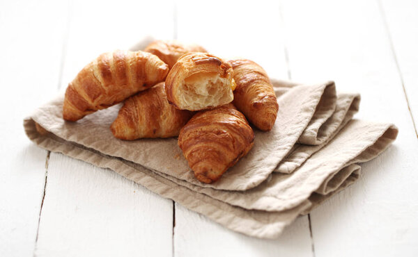 Fresh homemade french croissants on a linen tablecloth