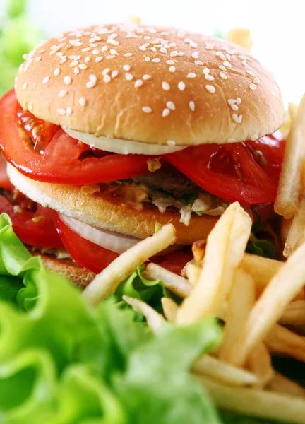 Salata yapraklarında ateş olan büyük ve lezzetli bir hamburger.