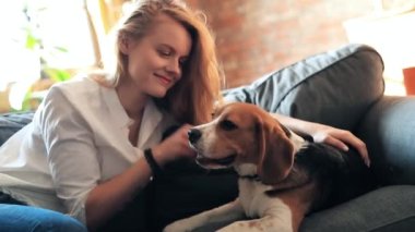 Evde köpekle oynayan güzel genç bir kadın.