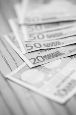 Tahta bir masanın üzerinde yığınla euro banknotları. 