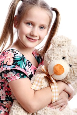 Beyaz arka plan üzerinde onun oyuncak ayı ile şirin kız