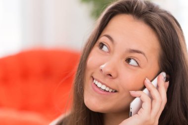 Evde akıllı telefonu olan güzel Asyalı bir kadın.