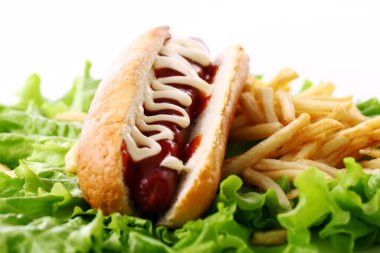 Salata yapraklarında kızarmış patatesli taze ve lezzetli sosisli sandviç.