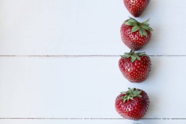 Beyaz, ahşap masadaki çilekler.