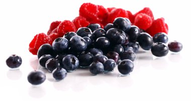 Beyaz arka planda taze ahududu ve yabanmersini.