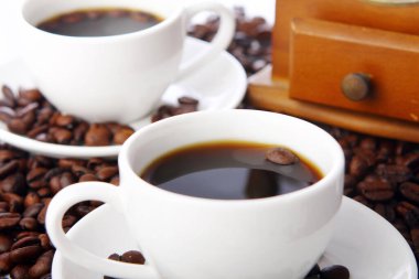 Masada beyaz bardaklı kahve çekirdekleri.