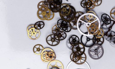 Detaylar, teknoloji. Beyaz arkaplanda küçük dişliler yığını