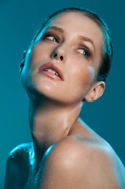 güzel bir kız ıslak deri ile mavi bir arka plan üzerinde poz
