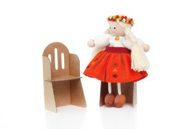  Beyaz arka planda karton sandalyeli küçük oyuncak bebek..