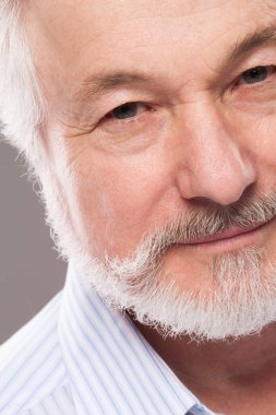 Geçmişi gri sakallı yakışıklı yaşlı bir adam.