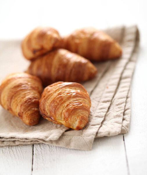 Fresh homemade french croissants on a linen tablecloth