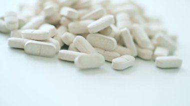 Arkaplanda beyaz haplar var.