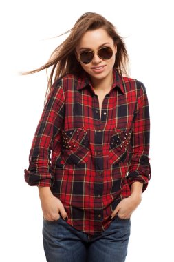 Kare gömlekli ve güneş gözlüklü çekici bir kadın.