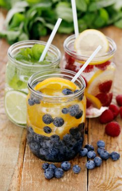 Tahta bir masada pipetle üç farklı soğuk içecek.