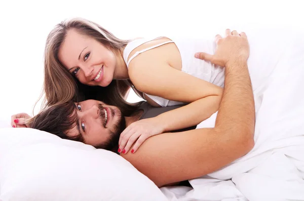 笑みを浮かべてカップル朝にベッドでリラックスします — Stock fotografie
