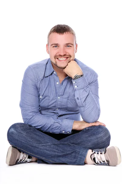 Pohledný Chlap Sedí Podlaze Nad Bílým Pozadím — Stock fotografie