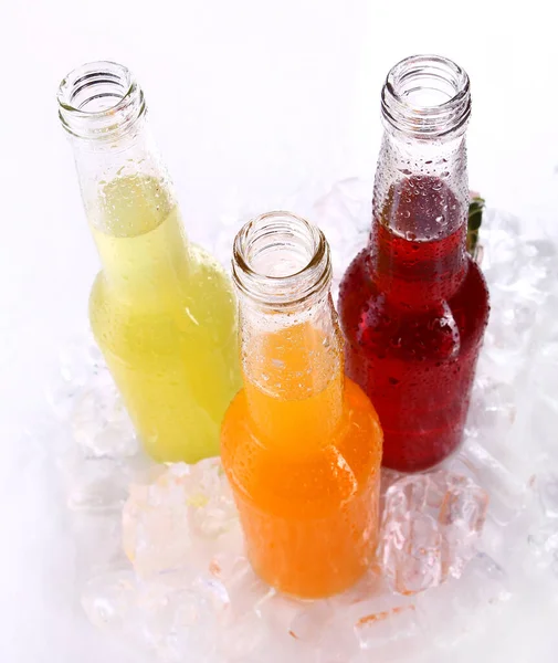 Flaschen Mit Buntem Cocktail Und Eis Auf Weißem Hintergrund — Stockfoto