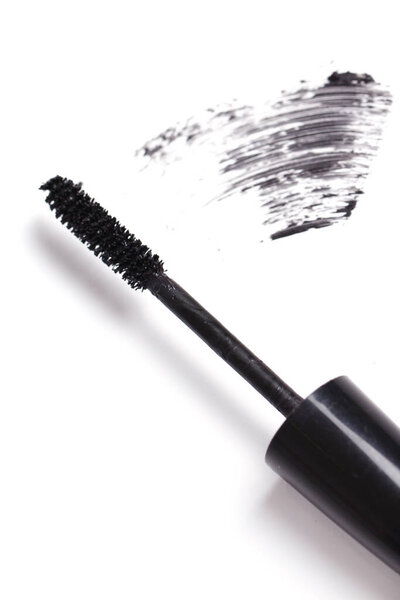 Brush of black mascara for eyes against white background