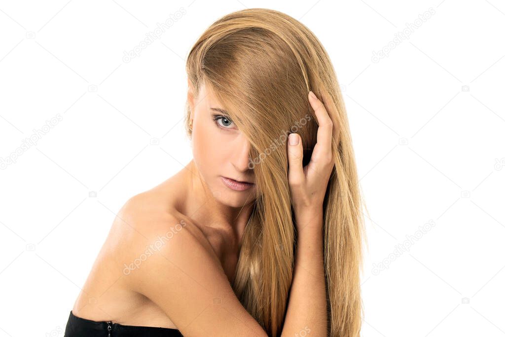 Portrait of a beautiful girl with blonde straight hair posing with naked shoulders over a white background