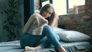 Genç ve güzel bir kadın evde dinleniyor. 