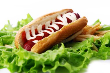 Salata yapraklarında kızarmış patatesli taze ve lezzetli sosisli sandviç.