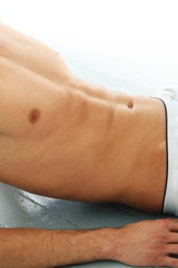 Beyaz bir arkaplanda spor yapan ve poz veren yakışıklı bir adamın portresi.