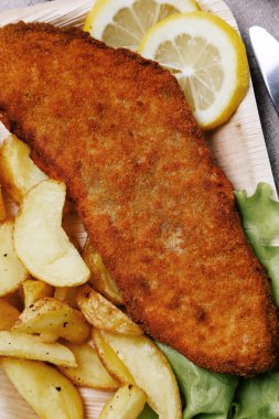 Masada patates olan lezzetli balık filetosu.