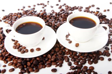 Masada beyaz bardaklı kahve çekirdekleri.