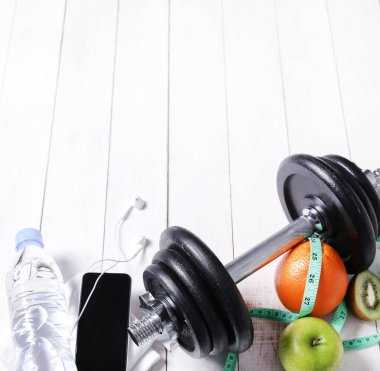 Sağlıklı bir hayat. Zeminde spor malzemeleri var.