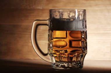 Ahşap yüzeyde bir bardak soğuk bira.