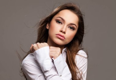 Gri arka planda yabancılaşma duygusu olan genç bir kadın.