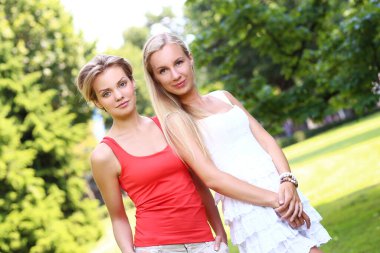 hoş çok eğlendiği parkta iki kız portresi. Onlar konuşuyor, tartışıyor, birbirlerine gülüyor ve gerçekten iyi eğlenceler