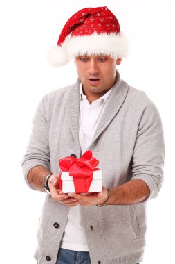 Beyaz arka planda gülümseyen Noel Baba şapkalı genç ve yakışıklı bir adam.