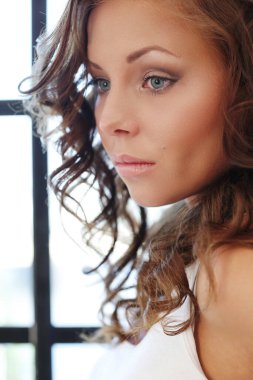 Güzellik. Evde kıvırcık saçlı güzel bir kadın var.