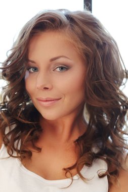 Güzellik. Evde kıvırcık saçlı güzel bir kadın var.