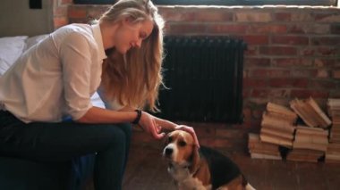 Evde köpekle oynayan güzel genç bir kadın.