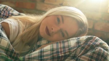 Genç ve güzel bir kadın evde dinleniyor. 